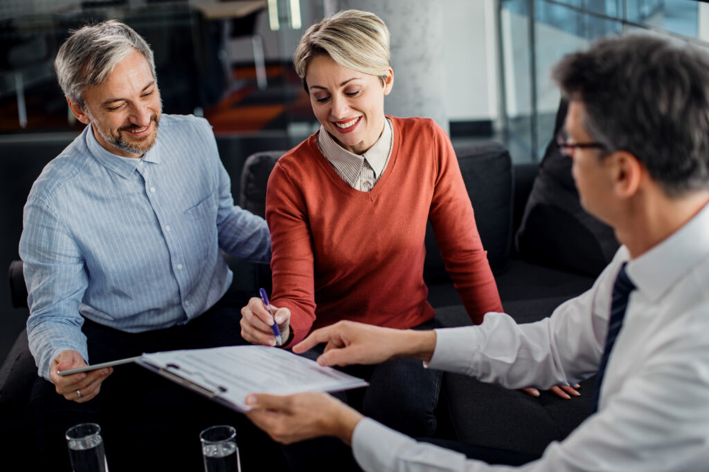 Why Is Insurance a Strategic Necessity for Businesses? 2 happy couple signing lease agreement with their agent meeting office Why Is Insurance a Strategic Necessity for Businesses?